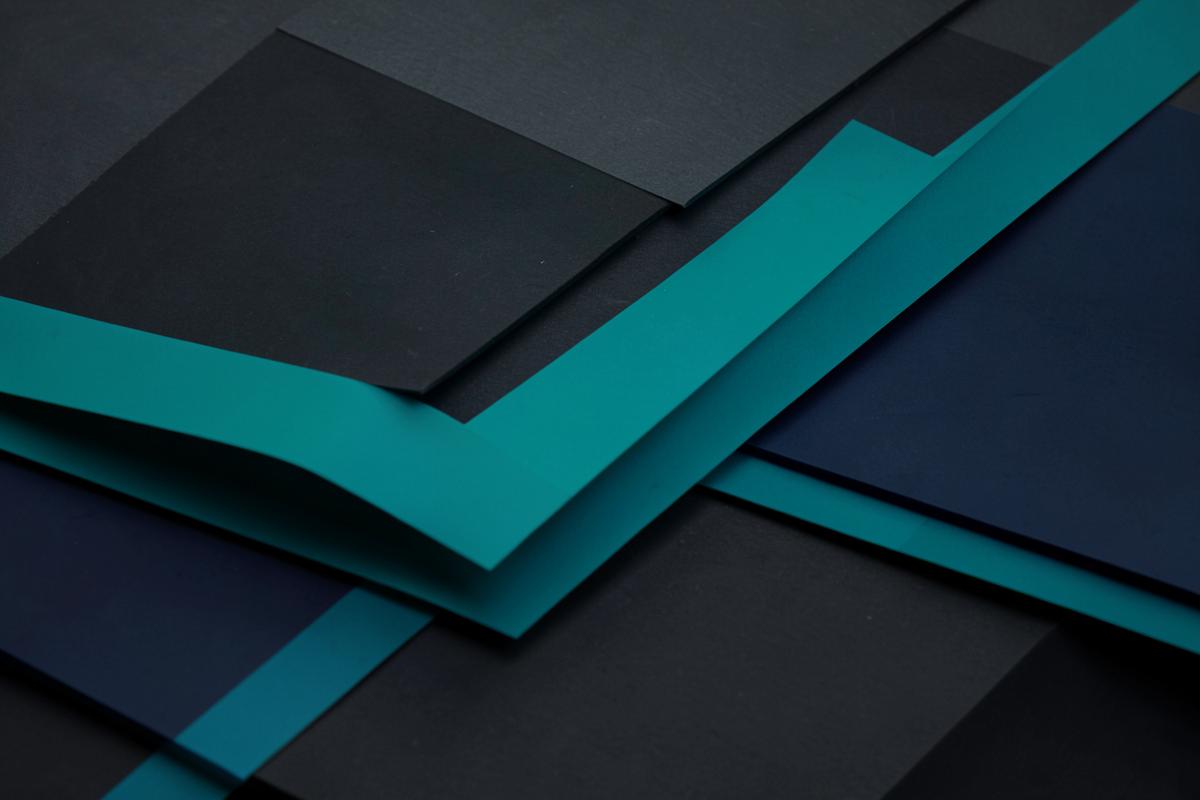 Layered navy and teal paper forms suggesting distributed data