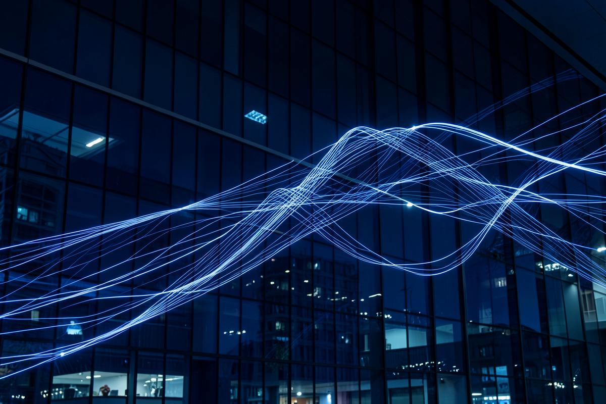 Light trails across a dark office facade representing newswire distribution